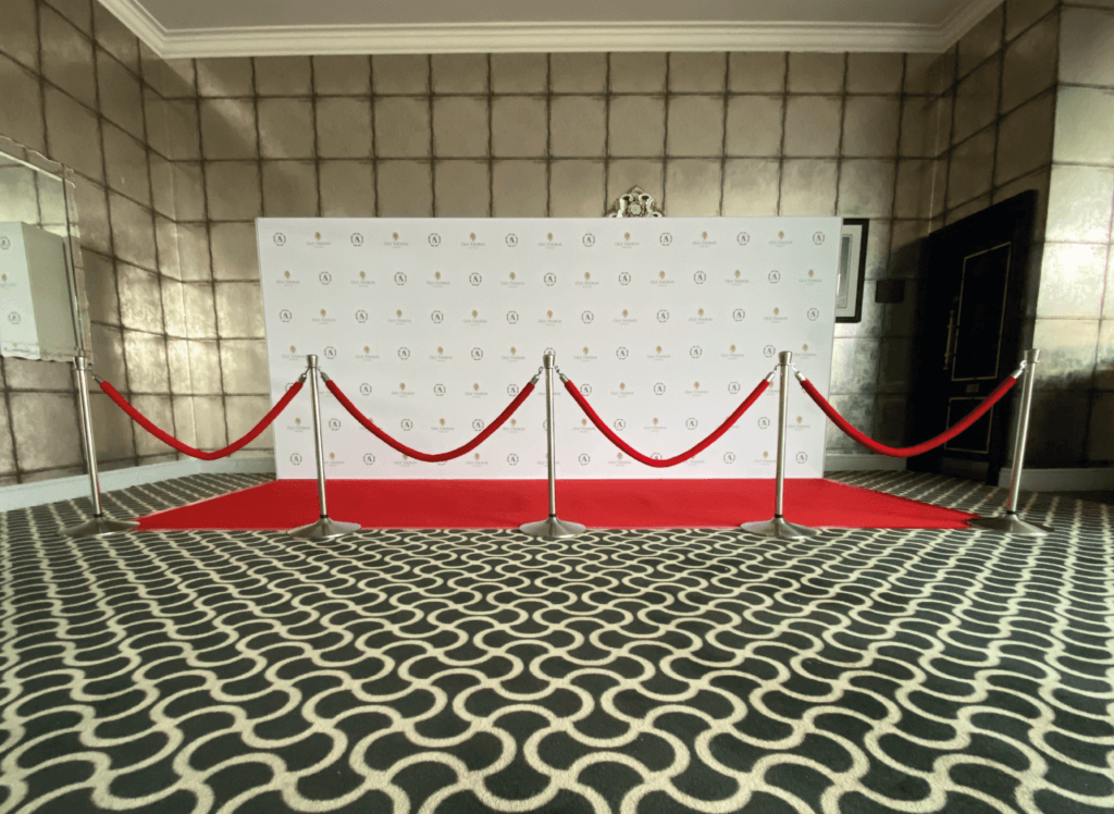 step and repeat board with red carpet, red ropes and stanchions